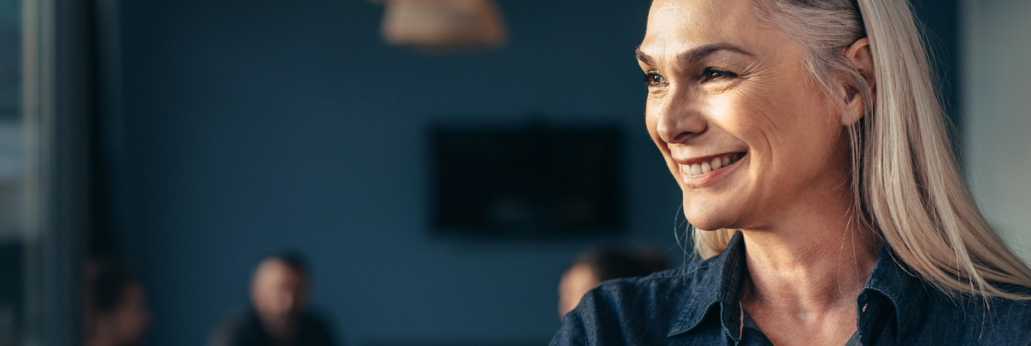 En leende kvinna står i förgrunden av tre andra personer.